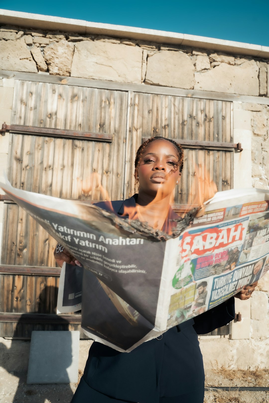 A vibrant, empowering portrait of a woman in a navy blue suit posing with attitude near the beach. The photo captures confidence, freedom, and individuality against a bright coastal backdrop — a fusion of style and energy under clear blue skie